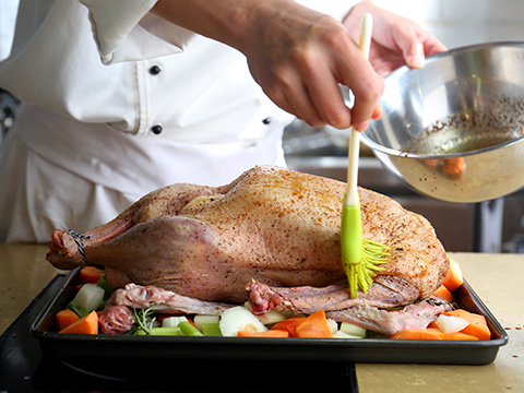 将橄榄油，2 大勺混合香辛料均匀涂抹于鹅的表层，确保涂抹均匀。