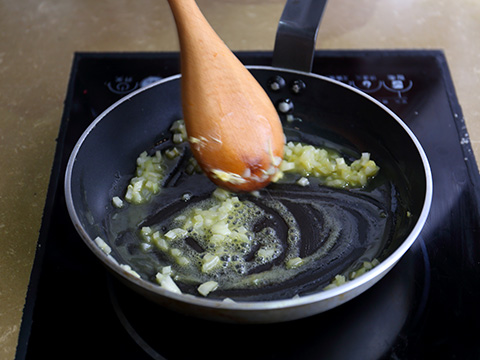 将一个大平底锅大火加热，加入黄油和白洋葱。