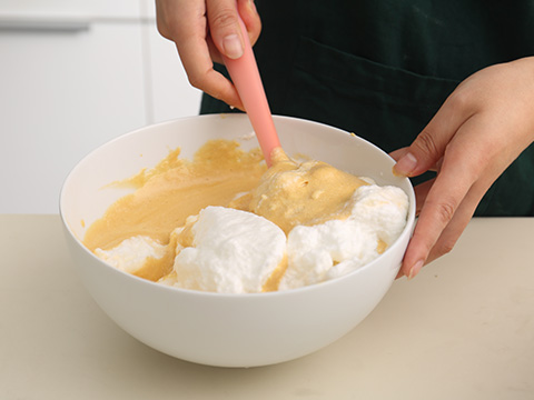 先放一半的蛋白到蛋黄里，用翻拌的手法翻拌。翻拌均匀之后，再加入另一半的蛋白到蛋黄中翻拌翻拌。