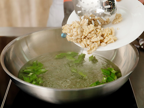 沸水烫熟，过冰水待用，然后鲜核桃仁入锅烫熟。