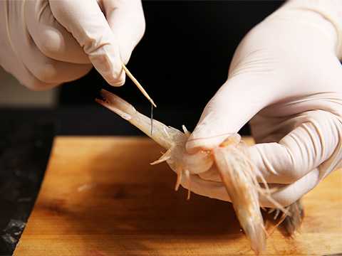 用剪刀将虾腔、虾须剪掉，用刀从虾腹部片一刀并剔去虾线；
